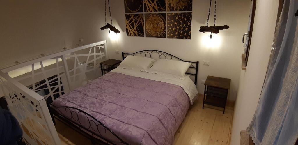 1 dormitorio con 1 cama con manta morada en B&B il Fienile del Borgo, en Iesi
