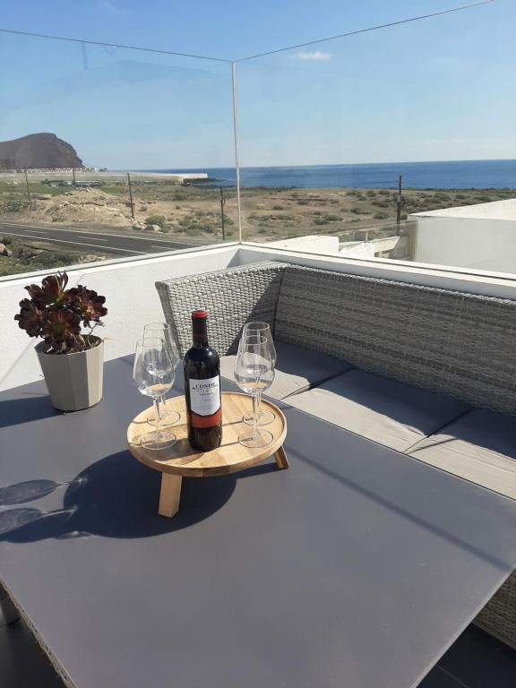 eine Flasche Wein und zwei Weingläser auf dem Tisch in der Unterkunft VILLA MARETA BEACH in La Mareta