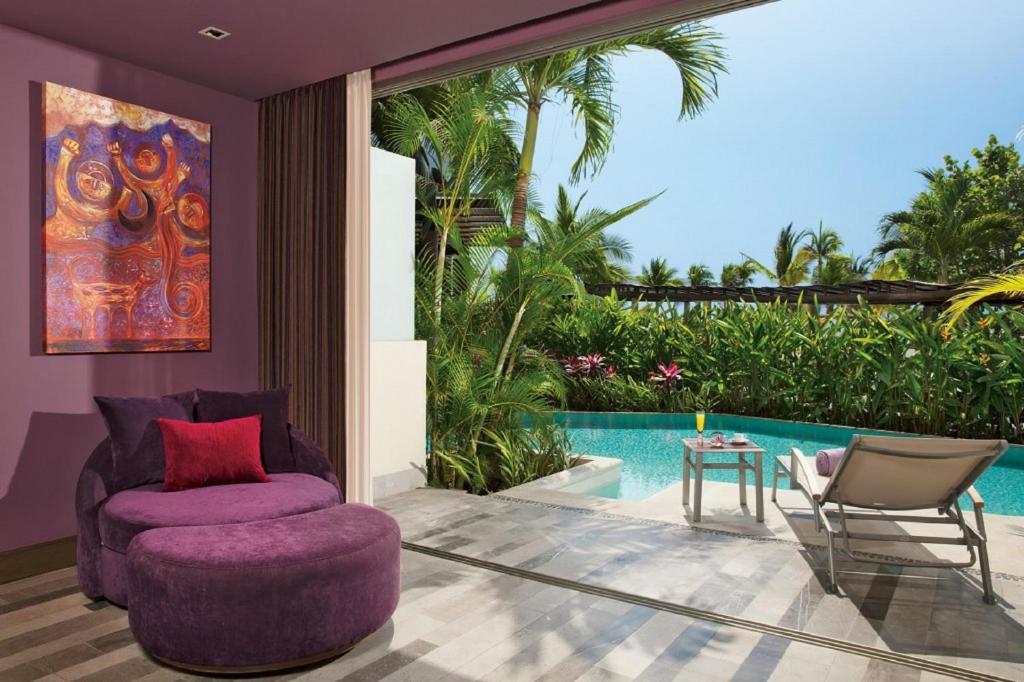a living room with a purple chair and a table at Secrets Vallarta Bay Resort & SPA - Adults Only in Puerto Vallarta