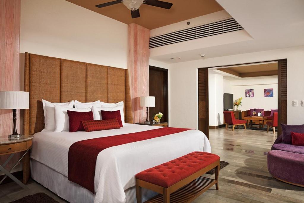 a hotel room with a large bed and a couch at Secrets Vallarta Bay Resort & SPA - Adults Only in Puerto Vallarta