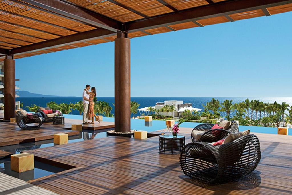 プエルト・バジャルタにあるSecrets Vallarta Bay Resort & SPA - Adults Onlyの海の景色を望むパティオ(椅子付)