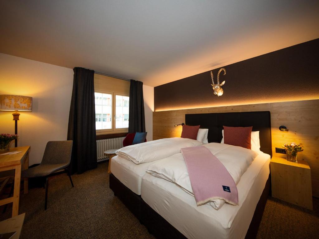 Postel nebo postele na pokoji v ubytování Hotel Parsenn