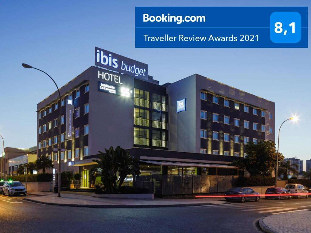 een hotel in een straat waar auto's voor geparkeerd staan bij Ibis Budget Málaga Aeropuerto Avenida de Velazquez in Málaga