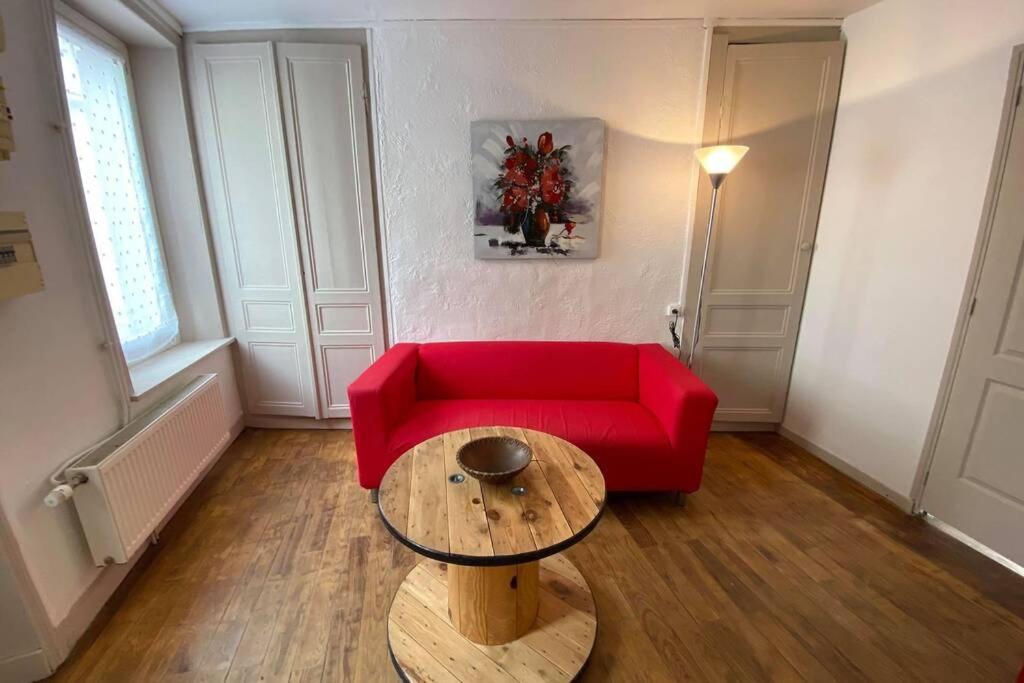 un salon avec un canapé rouge et une table dans l'établissement LA PERLE MARINE :Boulogne sur mer, à Boulogne-sur-Mer