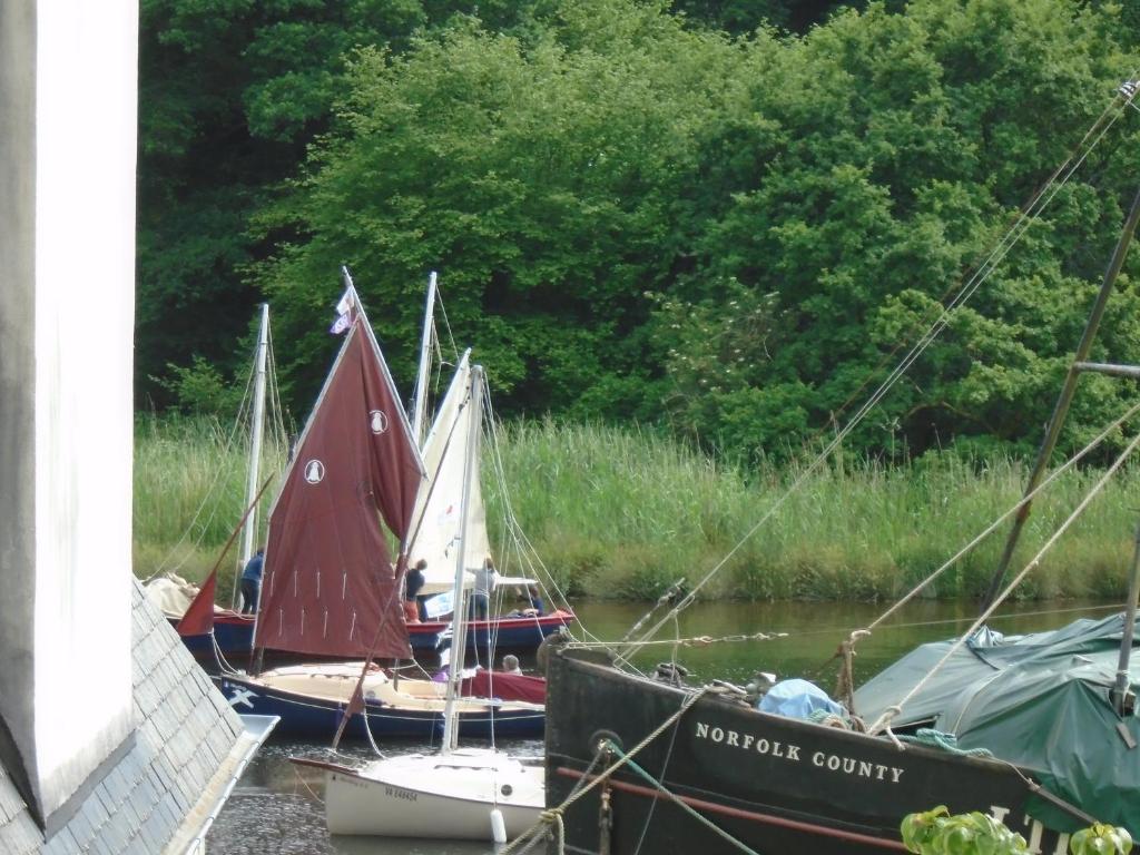 três pequenos barcos estão ancorados num rio em Crew Quarters Port Launay em Châteaulin