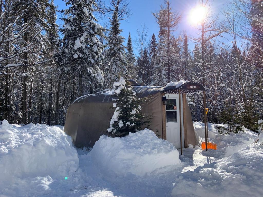 una pequeña cabaña cubierta de nieve en un bosque en Yourtes - Chalets Lanaudière, en Rawdon