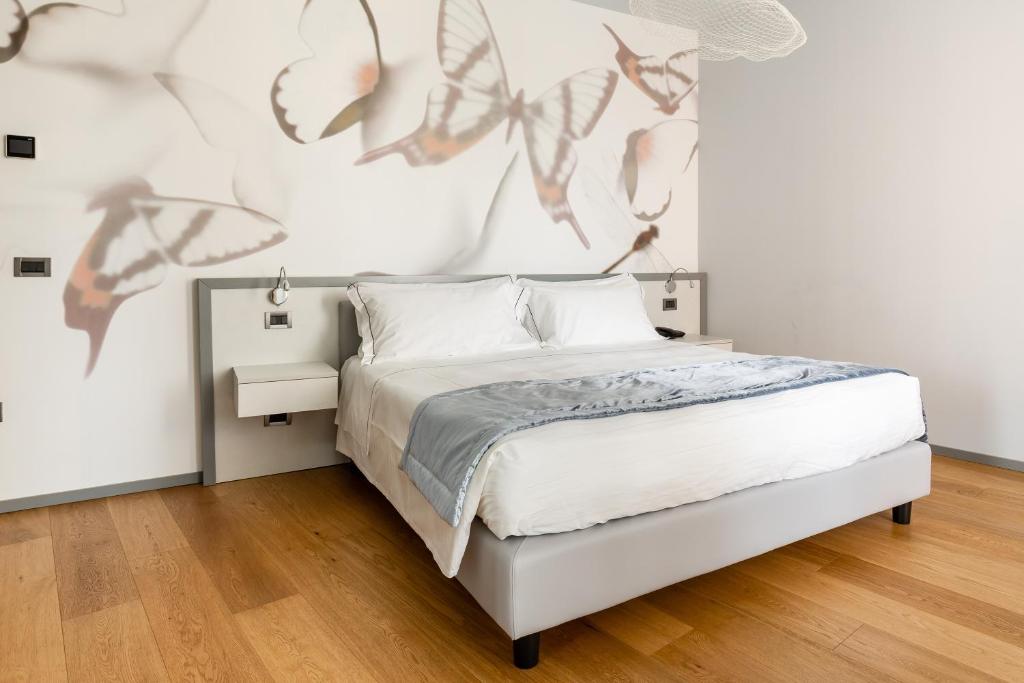 1 dormitorio con cama y pared con mariposas en Anusca Palace Hotel, en Castel San Pietro Terme