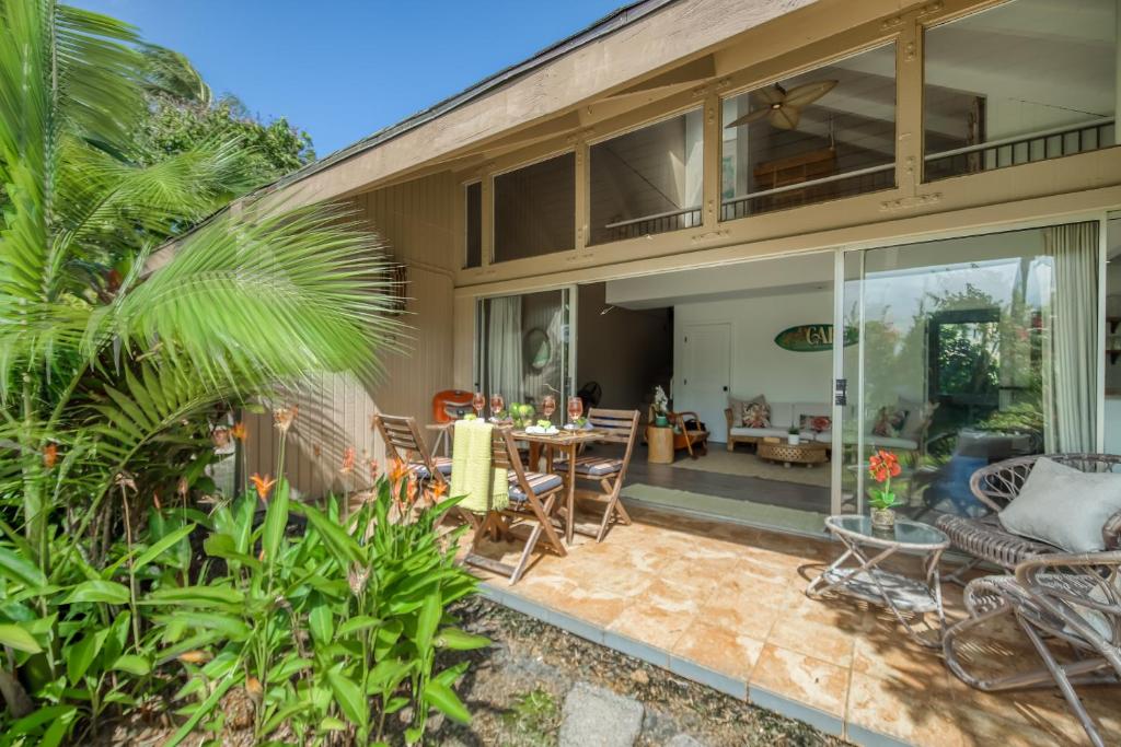 a house with a patio with a table and chairs at Pali Ke Kua #4 in Princeville