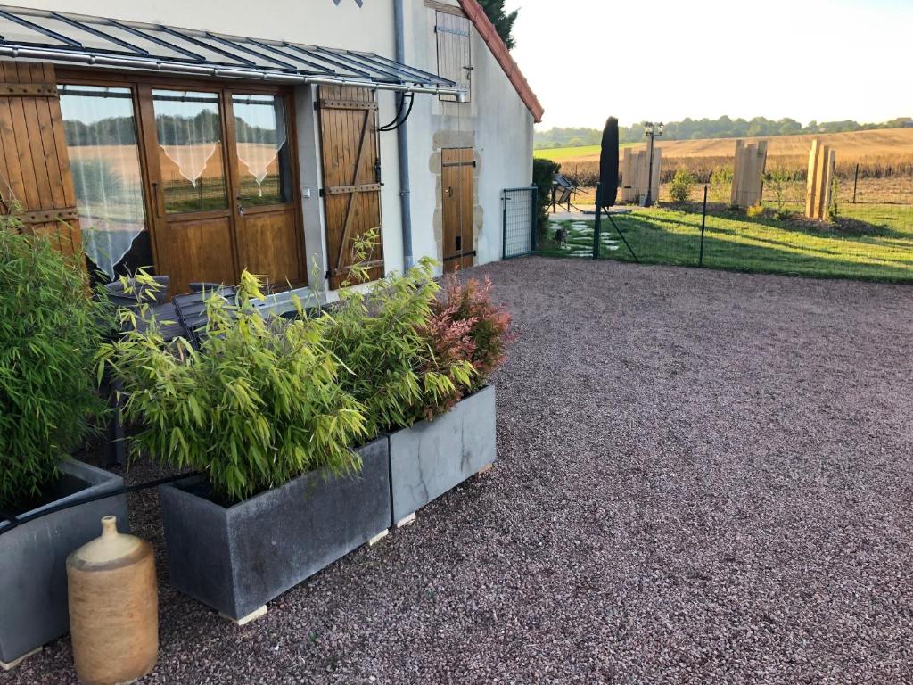 een patio met potplanten naast een gebouw bij Gîte La Ferranderie in Saint-Hilaire-de-Gondilly