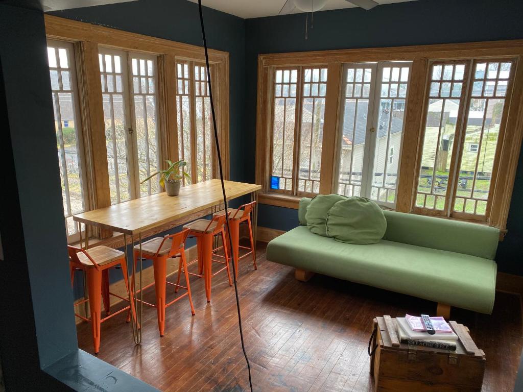 a living room with a table and a green couch at Uptown Treehouse in New Orleans