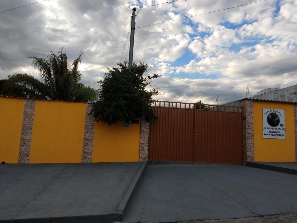 a orange fence with a gate with a driveway at Pouso do Beija-Flor in Cavalcante