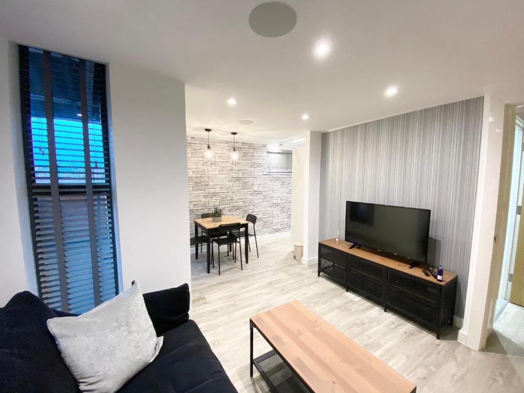 Cosy City Centre Location, Hydro Massage Showe في مانشستر: غرفة معيشة مع أريكة وتلفزيون بشاشة مسطحة