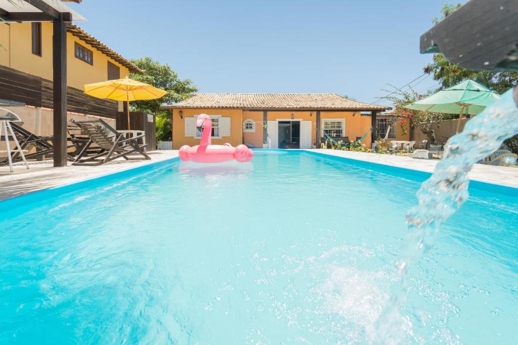 a swimming pool with a pink flamingo in the water at Kundalini Buzios in Búzios