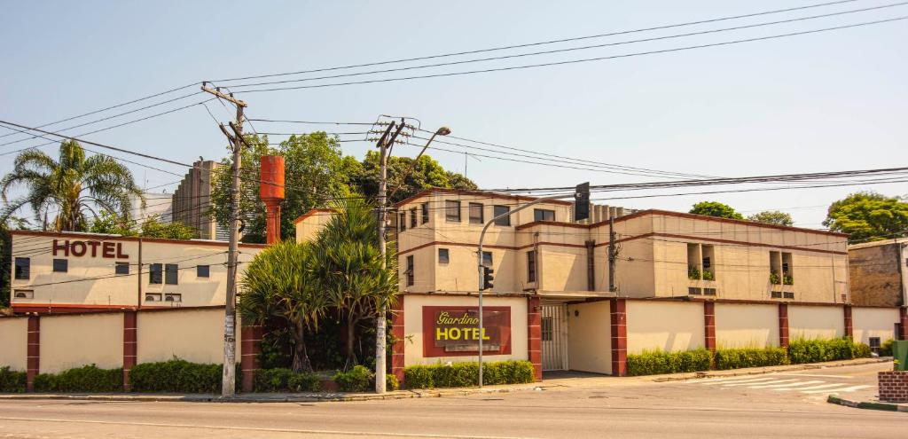 un vieux bâtiment au coin d'une rue dans l'établissement Giardino Hotel, à Itaquaquecetuba