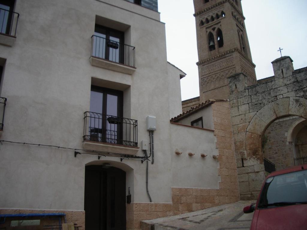 un edificio con una torre de reloj y una iglesia en Hostel El Castillo, en Ariñón