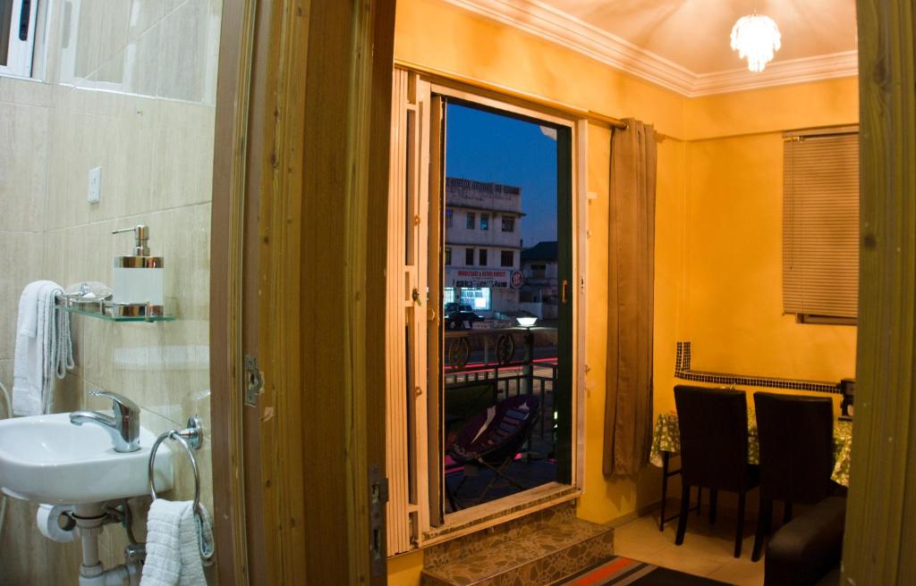 La salle de bains est pourvue d'un lavabo et d'une grande fenêtre. dans l'établissement Jesiwa B's Little Palace, à Accra