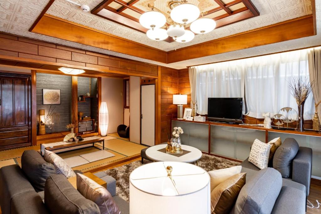 ein Wohnzimmer mit Sofa und Fernseher in der Unterkunft ASAHI HOUSE 2nd floor - Vacation STAY 92767 in Naha