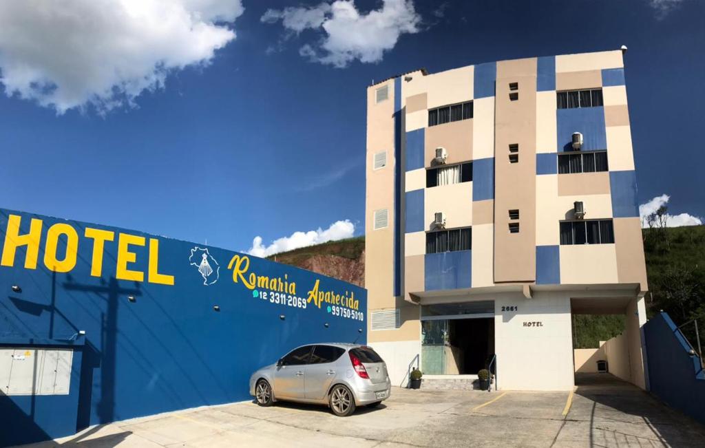 a car parked in a parking lot in front of a hotel at Hotel Romaria Aparecida in Aparecida