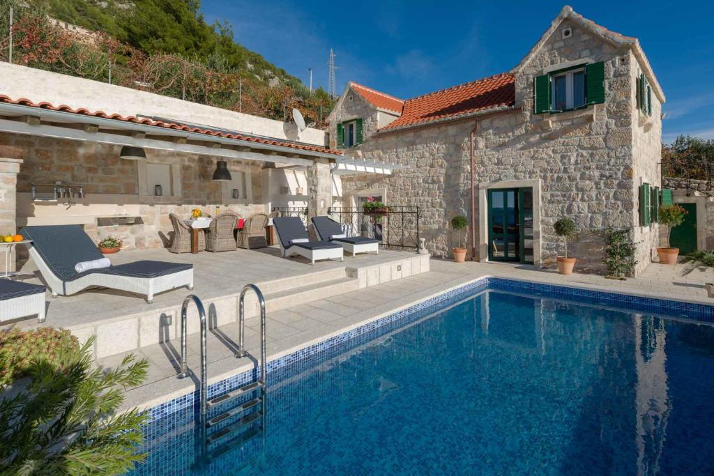 una casa con piscina al lado de un edificio en Villa Belle Murvica An Exquisite 3 Bedroom Villa Overlooking the Adriatic Sea, en Murvica