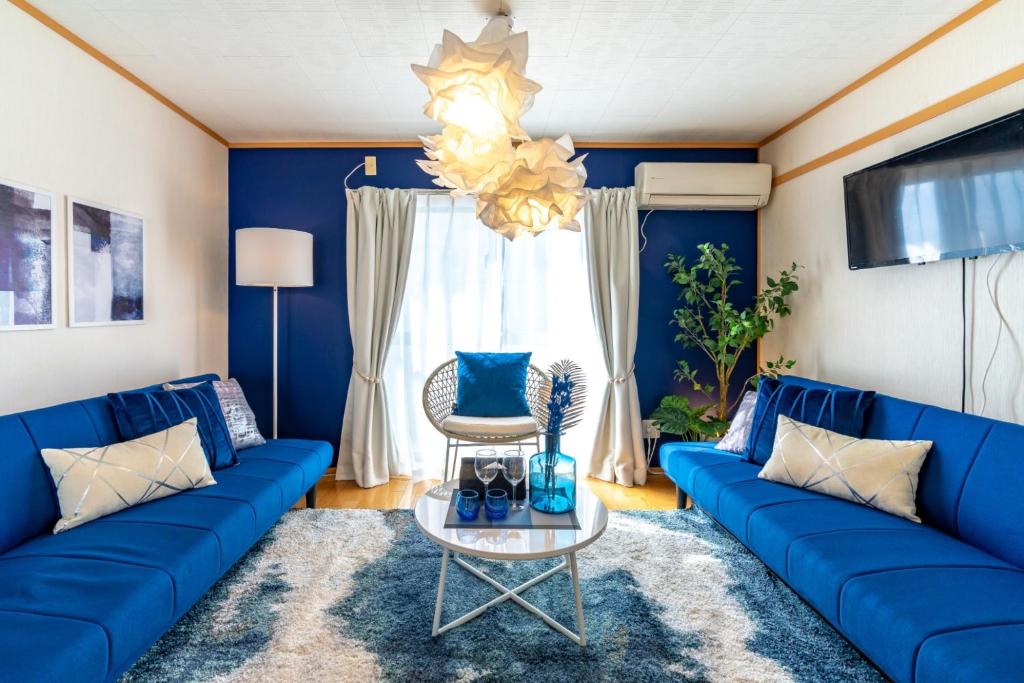 Sala de estar azul con sofá azul y mesa en ASAHI HOUSE 2nd floor - Vacation STAY 92770, en Naha