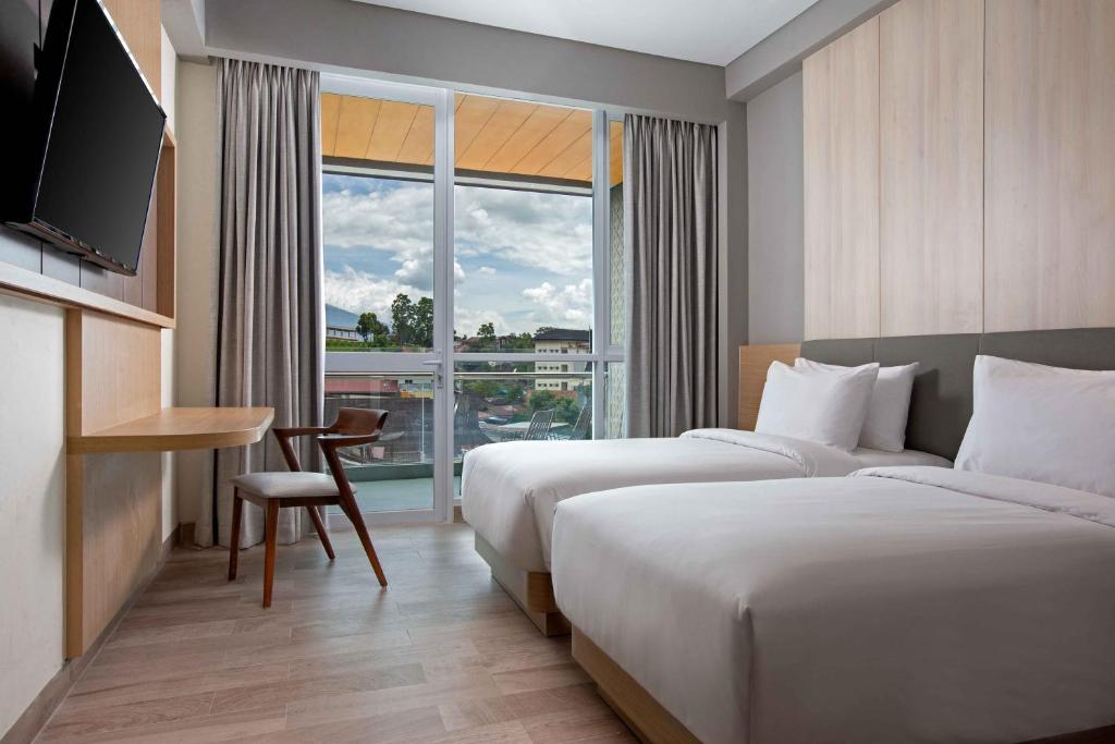 Postel nebo postele na pokoji v ubytování Hotel Santika Bukittinggi