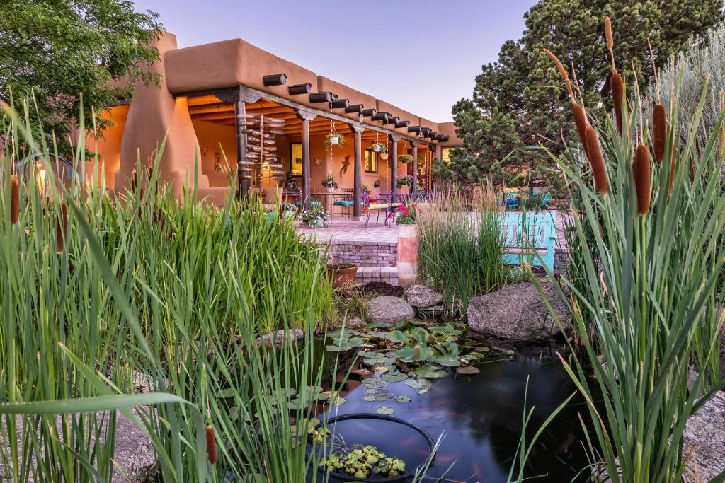 une maison avec un étang en face de celle-ci dans l'établissement Bobcat Inn, à Santa Fe