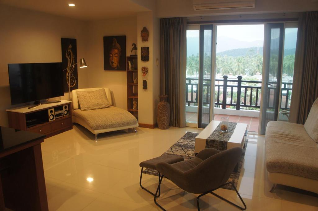 a living room with a television and a balcony at Khanom Beach Residence Sea & Mountain View - 1 Bedroom in Ban Na Dan