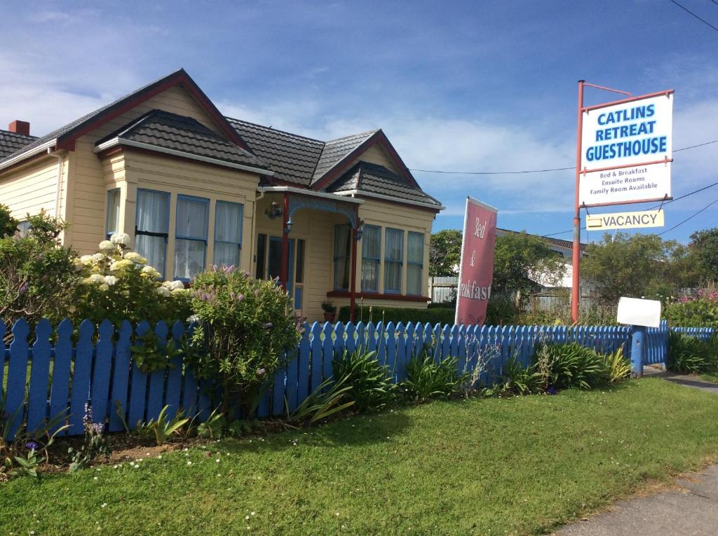una casa con una valla azul y una señal en Catlins Retreat B & B en Owaka