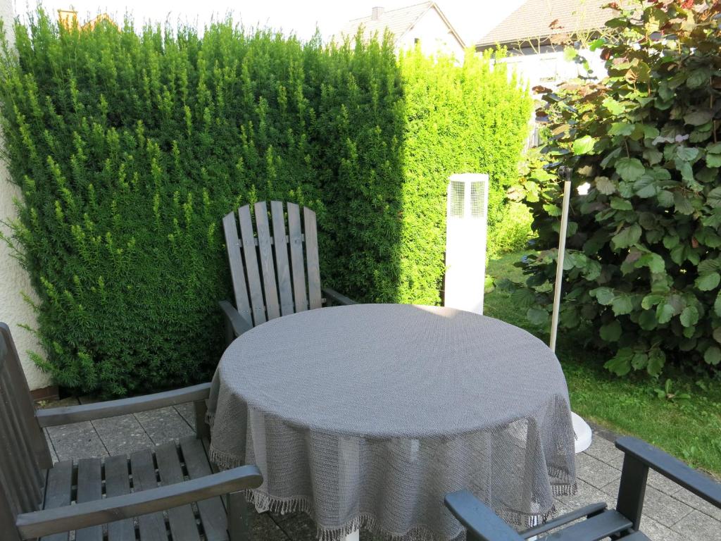 stół i krzesła w ogrodzie z żywopłotem w obiekcie Wohnung für Liebhaber - gerne auch mit Kindern w mieście Sundern (Sauerland)