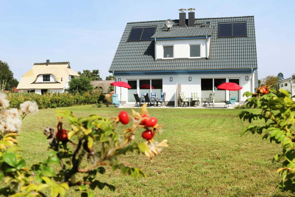 a house with red umbrellas in a yard at Ferienhaus Wis mit Sauna in Ostseebad Karlshagen