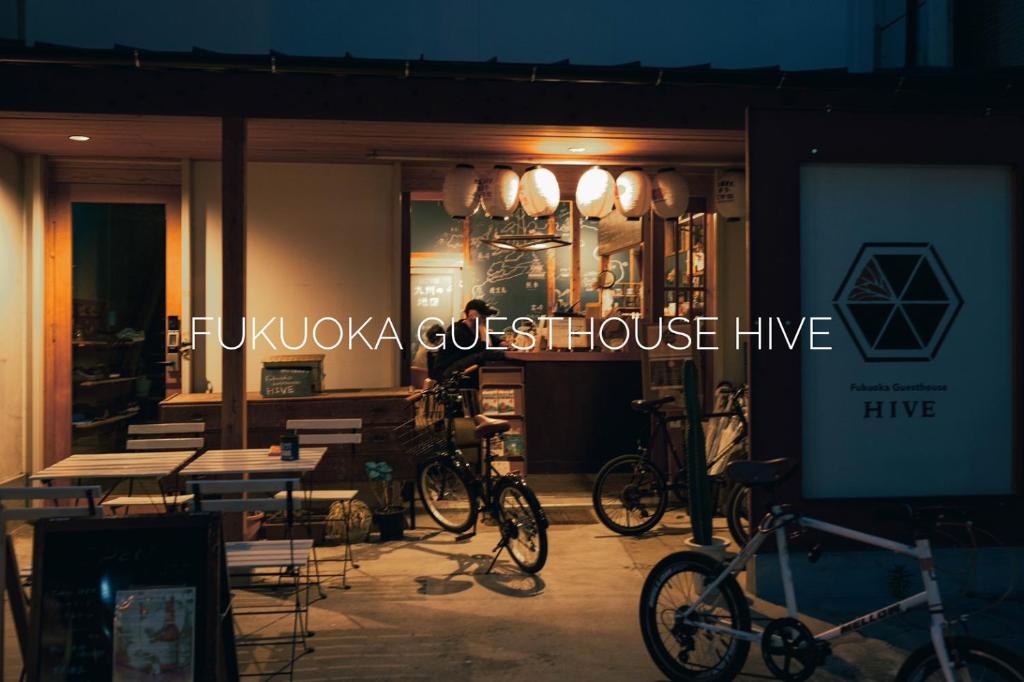 Fukuoka Guesthouse HIVE في فوكوكا: مطعم به دراجات متوقفة في الخارج في الليل