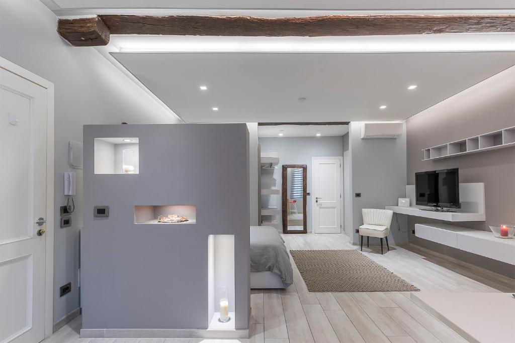 a white room with a bed and a tv in it at MANDRIA APARTMENTS 1 2 in Bologna