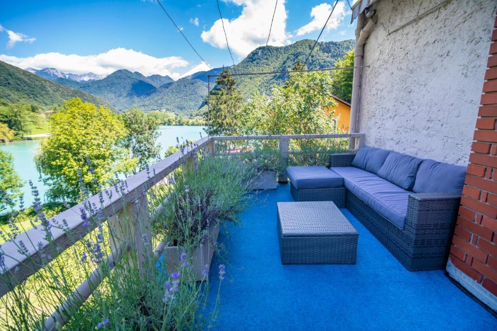 d'une terrasse avec un canapé et des chaises sur un balcon. dans l'établissement House by the Lake, à Most na Soči