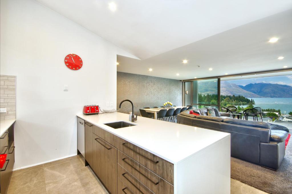 a kitchen and living room with a view of the ocean at Luxury on the Lake in Queenstown