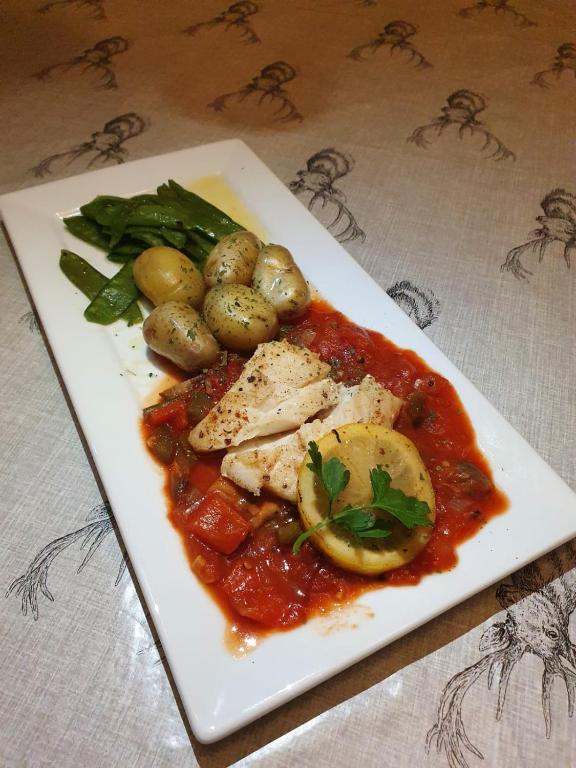 a plate of food with chicken and vegetables on a table at Kintrae B&B in Buckie