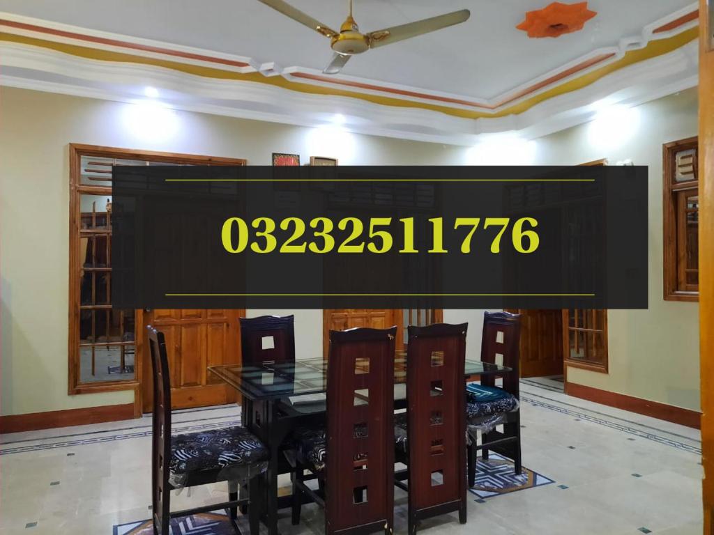 a sign in a dining room with a table and chairs at Palace inn Guest House in Karachi
