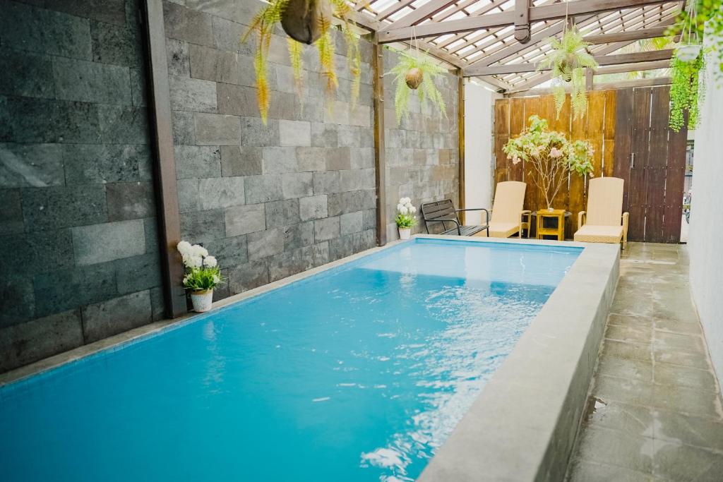 a large blue swimming pool in a house at OstiC House in Yogyakarta