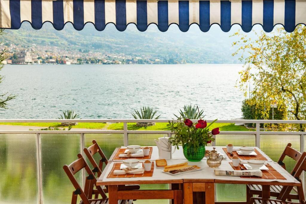 a table on a balcony with a view of the water at Casa Rodella in Marone