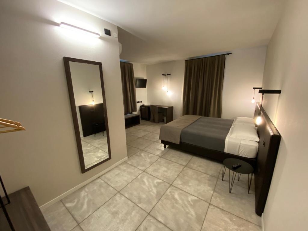 una camera d'albergo con letto e specchio di taverna napoleone a San Lorenzo