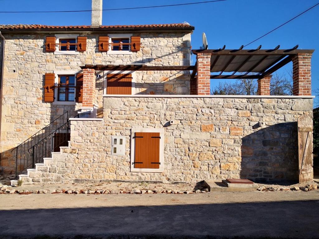 a stone building with a door and a staircase at Apartment Paulina in a Stone House in Jakići