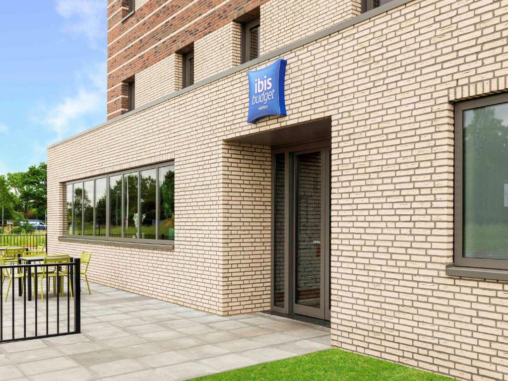 a brick building with a blue sign on it at ibis budget Stein Maastricht in Stein