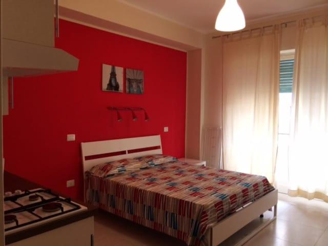 a red bedroom with a bed and a stove at Suite La Rosa Dei Venti in Catanzaro