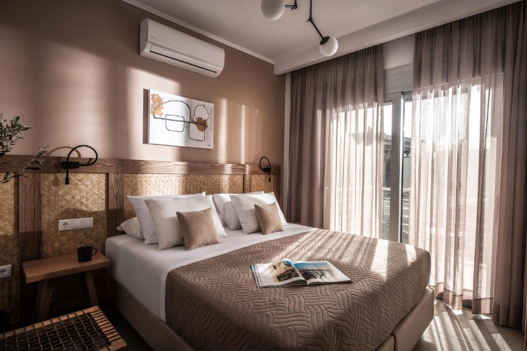 een hotelkamer met een bed met een tijdschrift erop bij Aether by Nymphs residence I in Kókkinos Pírgos
