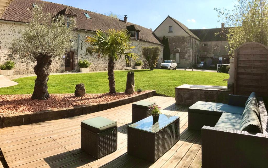 a patio with benches and tables in a yard at Gîte de l'Homme Blanc in Soizy-aux-Bois