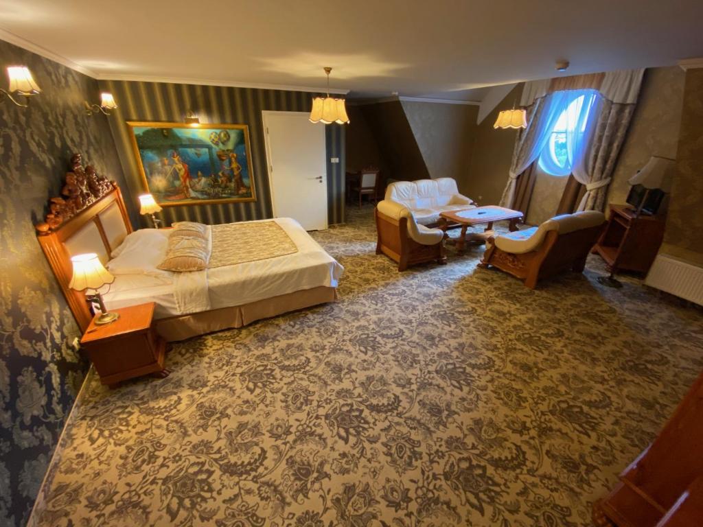 um quarto de hotel com uma cama e uma sala de estar em Hotel Pałac Borynia em Jastrzębie Zdrój