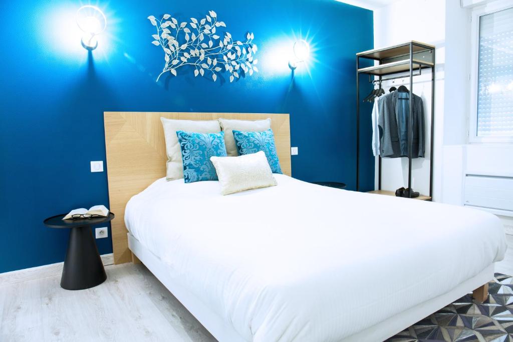 sypialnia z dużym białym łóżkiem z niebieskimi ścianami w obiekcie Château du Rollin Orléans - La Chapelle St Mesmin w mieście Chapelle-Saint-Mesmin