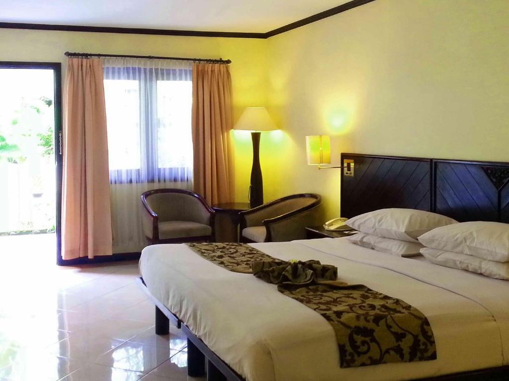 Postel nebo postele na pokoji v ubytování Legian Paradiso Hotel