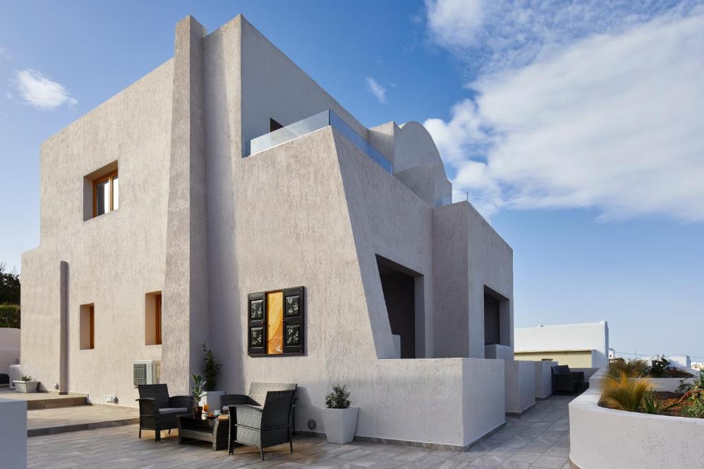 a building with chairs and tables in front of it at Alyvia Suites in Oia