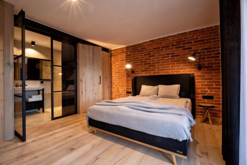 een slaapkamer met een groot bed en een bakstenen muur bij Jazzowa Chata in Bielsko-Biala