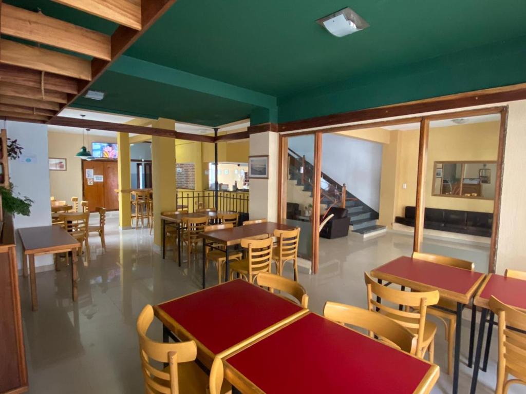a dining room with tables and chairs and windows at Hotel Roma in Mar de Ajó